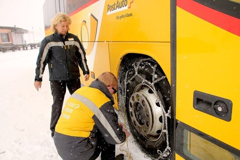 Pose de chaînes à neige sur une roue en conditions hivernales